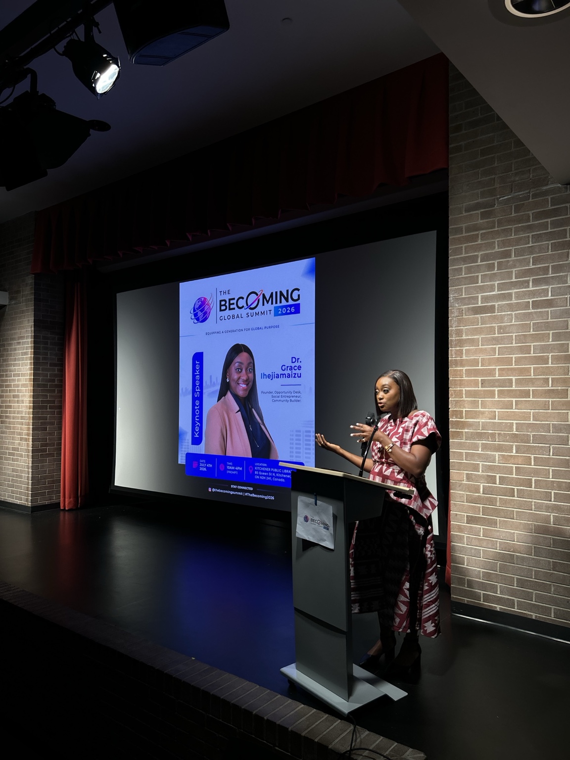 A speaker addresses the Becoming Global Summit from the lectern at Kitchener Public Library.
